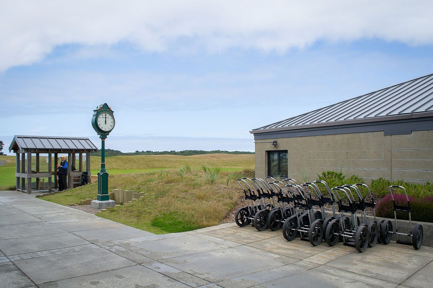 Starter's hut, clock and a row of push carts beside the first tee at Bandon Dunes Golf Resort, Oregon
