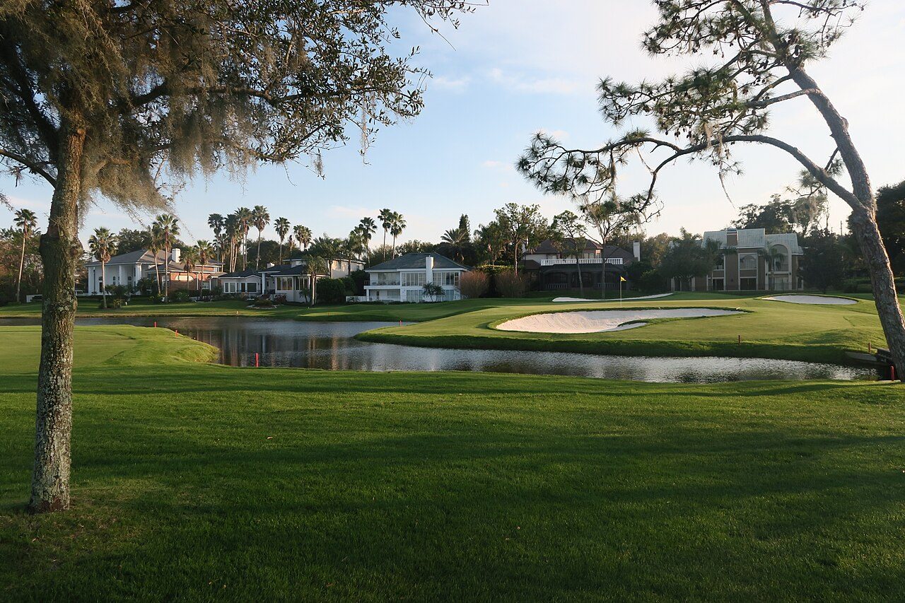 Pond in front of the 16th green at Bay Hill Club and Lodge in Orlando, with oaks and palms around it
