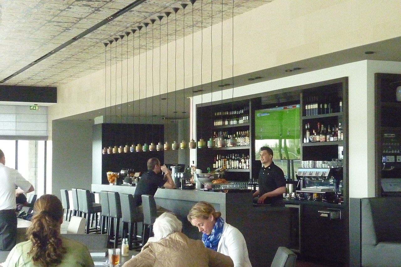 Golfers and staff at the bar of a golf clubhouse