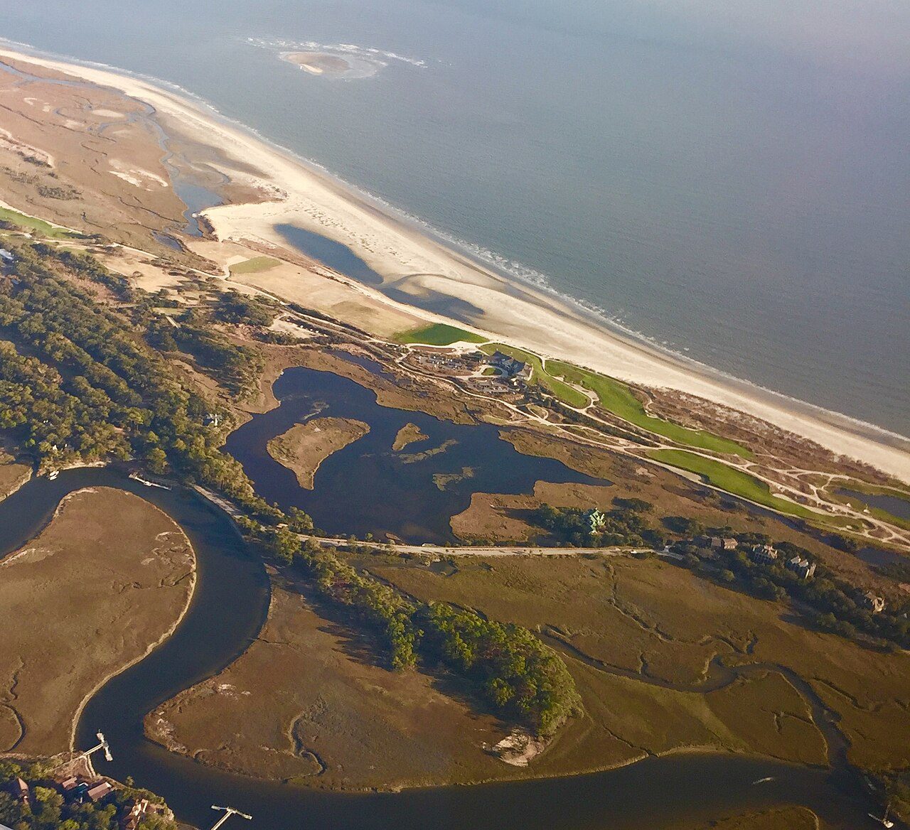 Aerial view of the eastern end of Kiawah Island, with the Ocean Course's fairways running between salt marsh and the beach