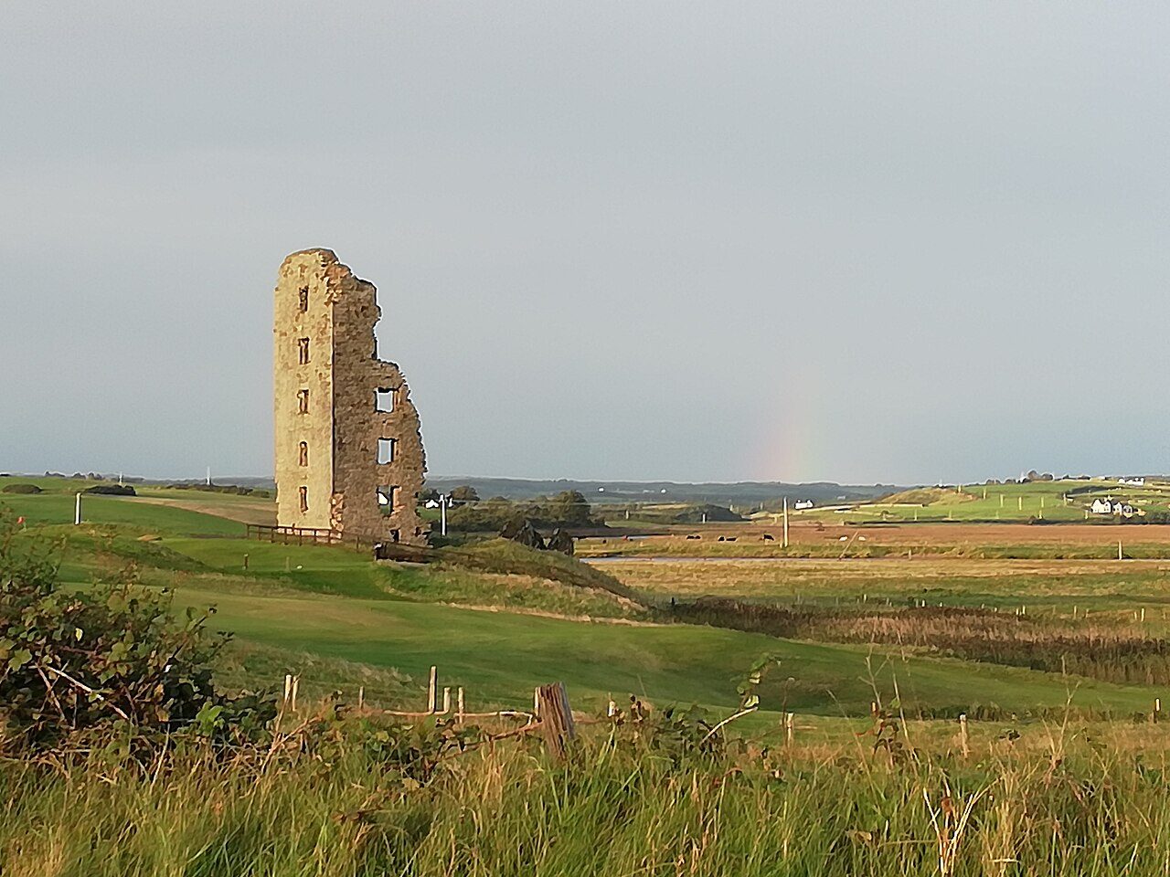 The Old Course at Lahinch, with a ruined castle tower beside the links