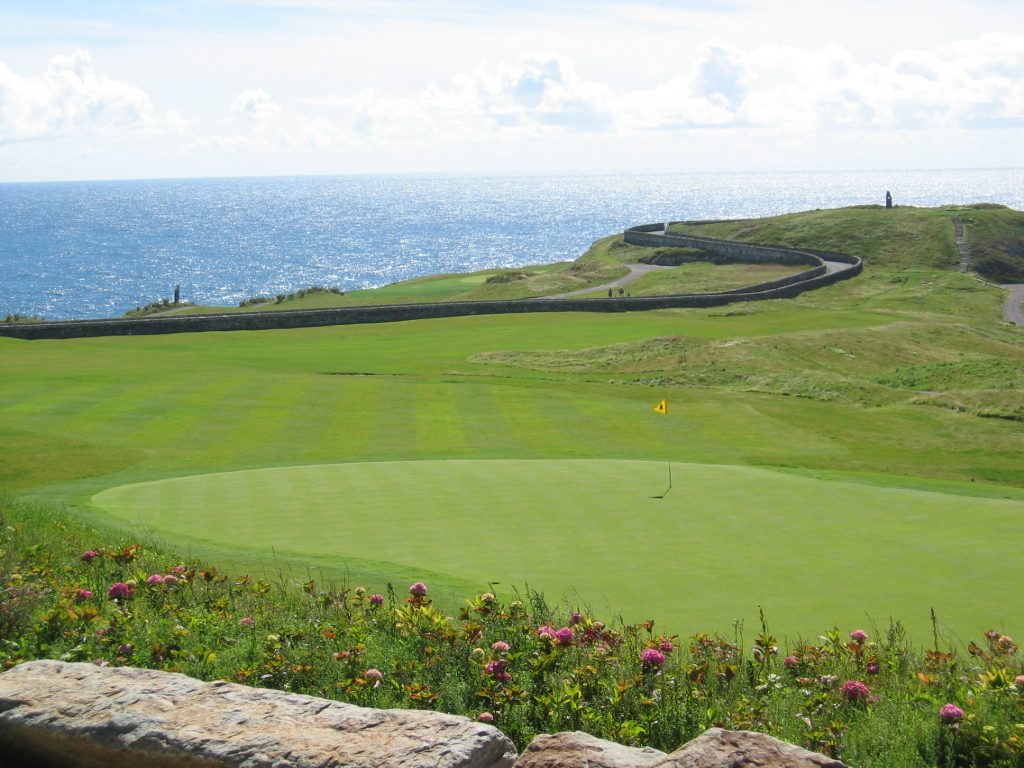 The green of a clifftop hole at Old Head Golf Links, with the Atlantic beyond