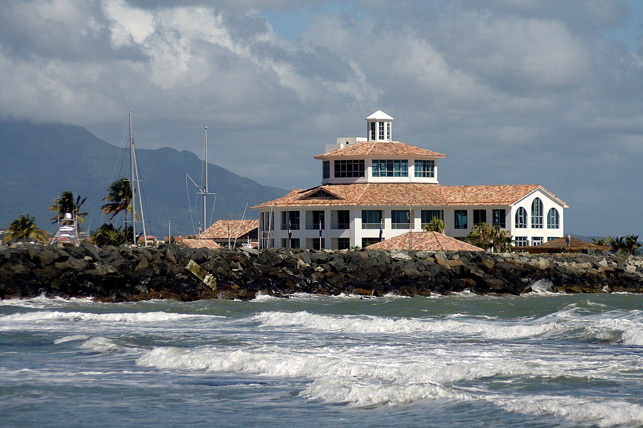 Clubhouse at Palmas del Mar's yacht club in Humacao, Puerto Rico, on a rocky breakwater with mountains behind