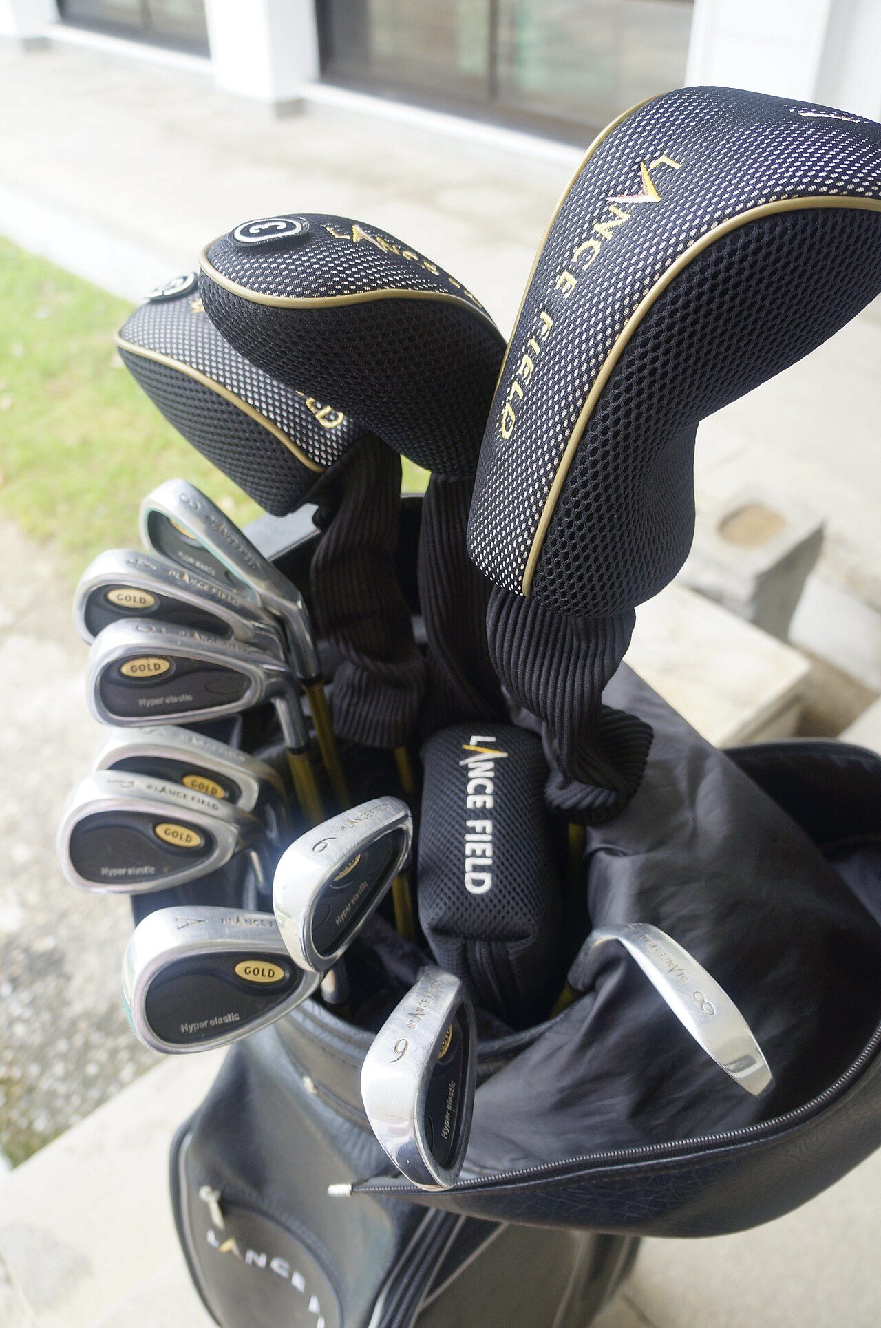 A rental set of golf clubs with headcovers on the drivers and woods
