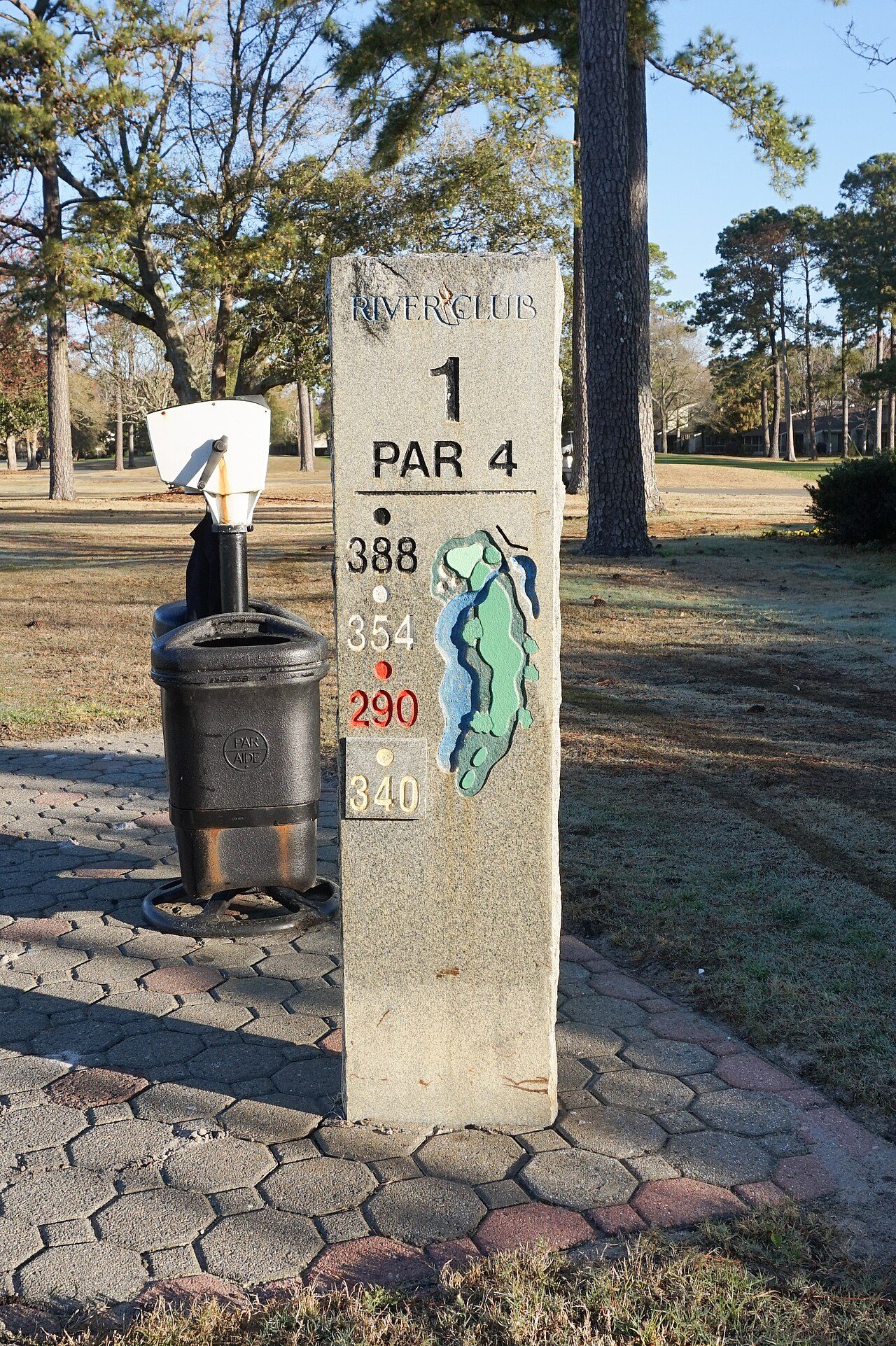 The first tee sign at River Club in Pawleys Island, among pines
