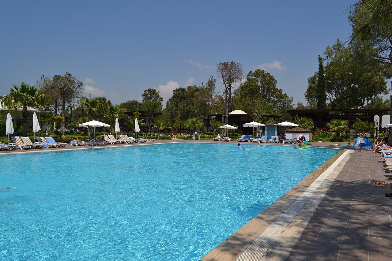 Swimming pool with sun loungers and palm trees at a golf hotel in Side, on Turkey's Mediterranean coast