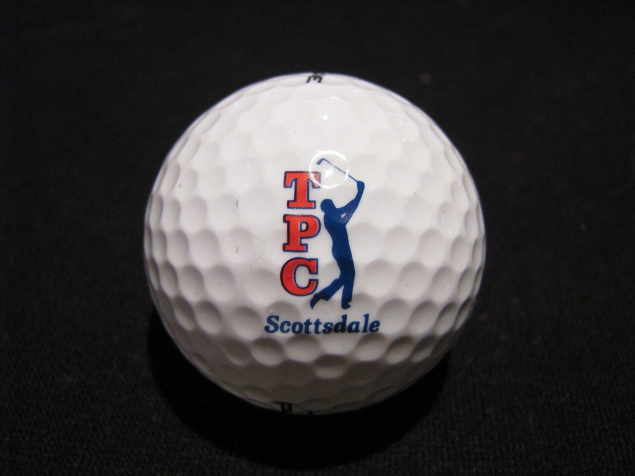 A white golf ball printed with the red and blue TPC Scottsdale logo