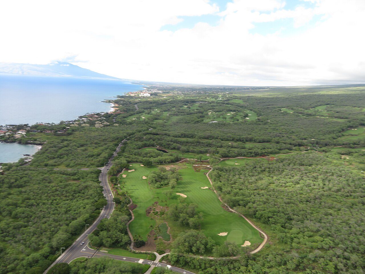 Aerial view of Wailea on Maui, with golf fairways running through dry scrub between the resort and the coast