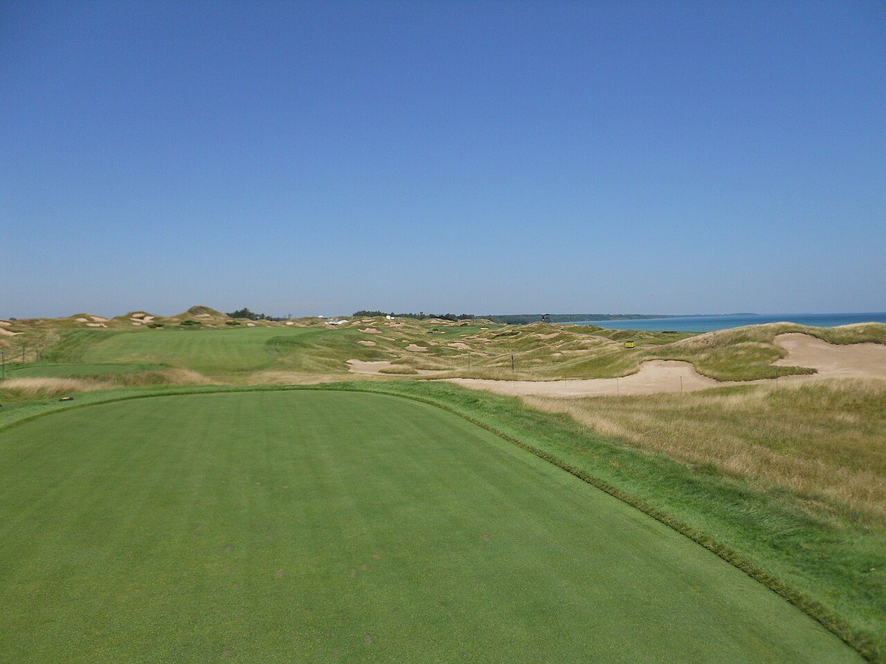 Fescue-framed fairway of the 11th hole on the Straits Course at Whistling Straits, with Lake Michigan behind the dunes