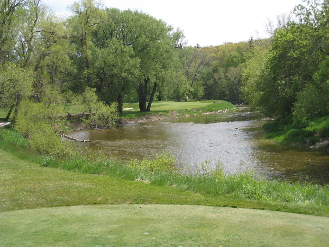 The Sheboygan River winding past a green on the River Course at Blackwolf Run in Kohler, Wisconsin
