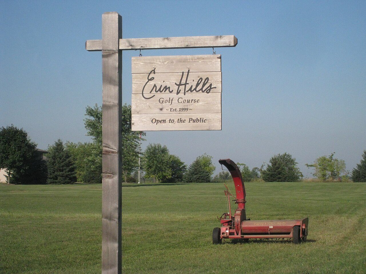 The wooden Erin Hills sign reading "Open to the Public" beside a fairway in Wisconsin