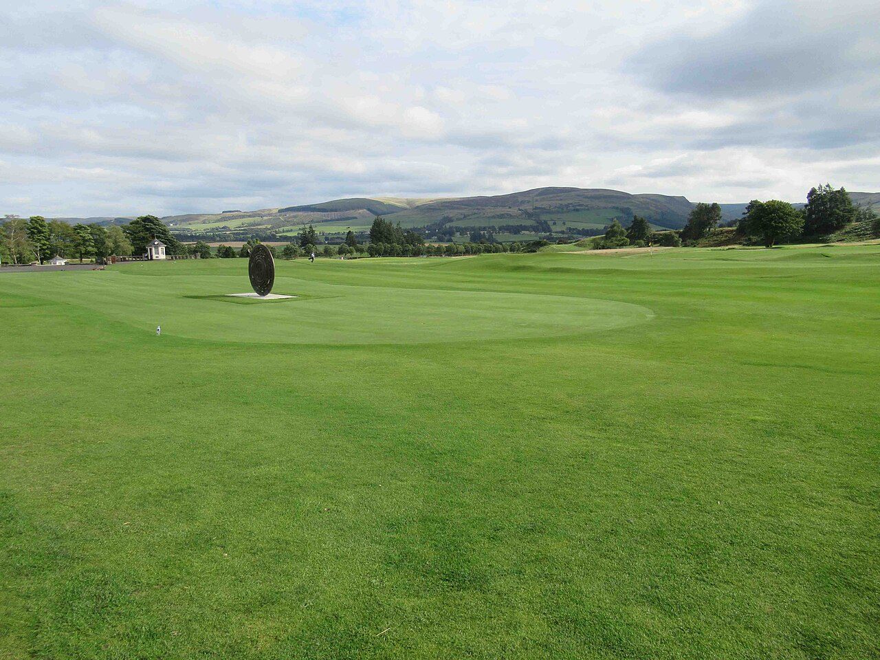 A green on the golf course at Gleneagles in Perthshire, with hills beyond
