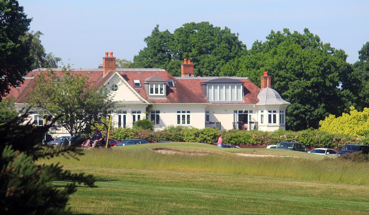 The red-roofed clubhouse at Sunningdale Golf Club seen across the lawn from the course